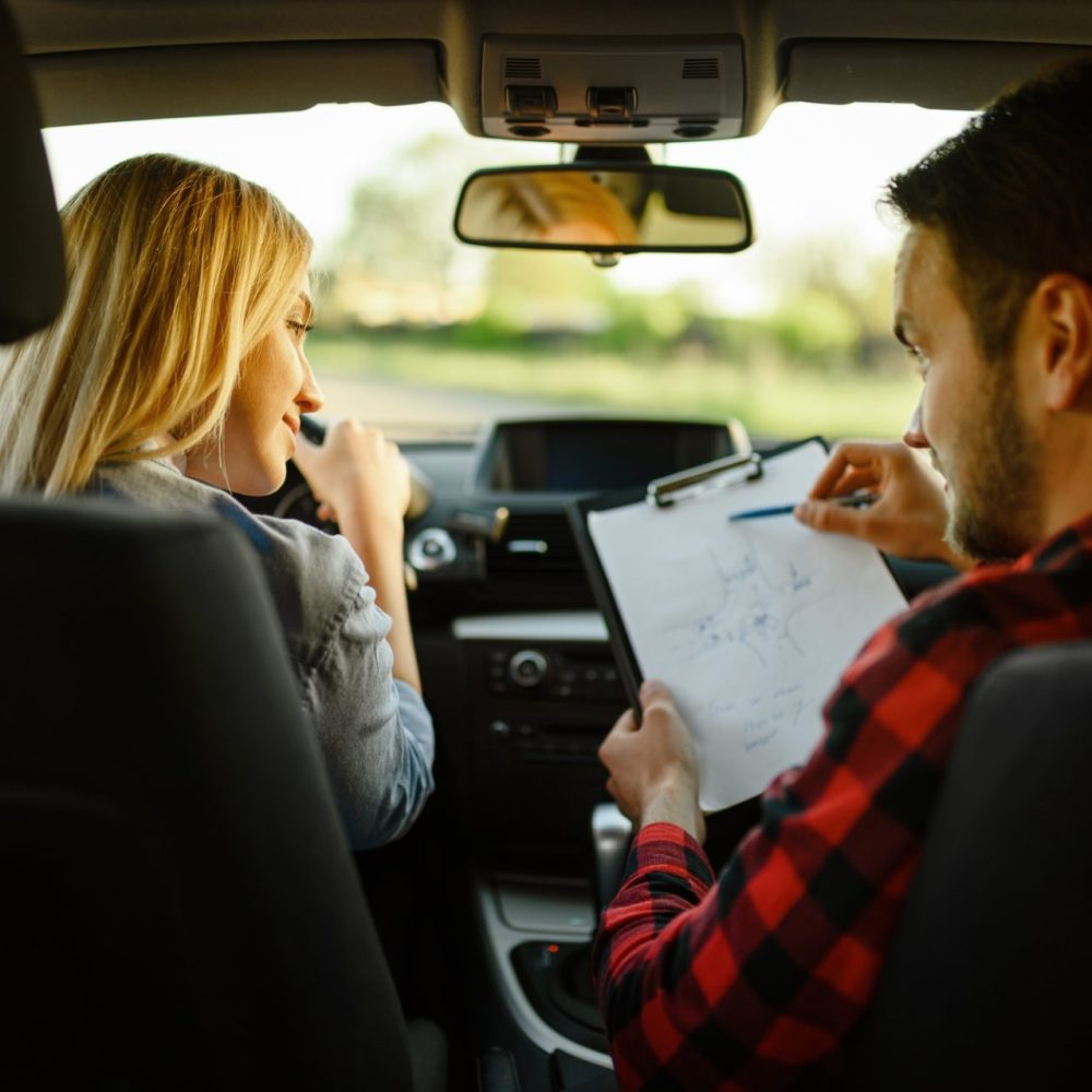 instructor-helps-woman-to-drive-the-car-e1627375431416.jpg